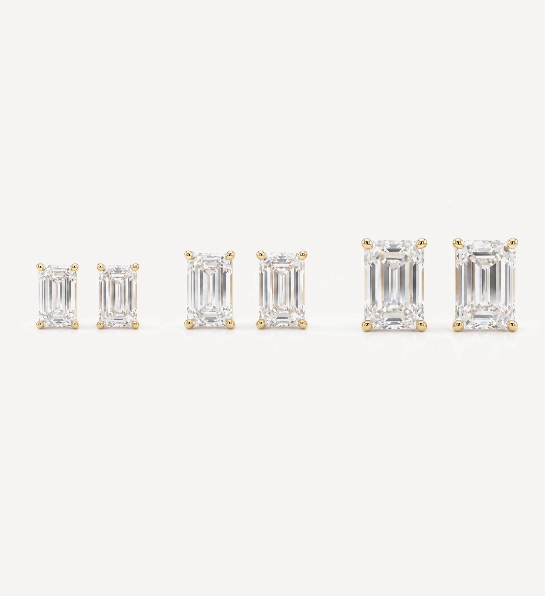 Grace emerald-cut diamond stud earrings in yellow gold, displayed from small to large sizes with emerald-cut diamonds in four-prong settings